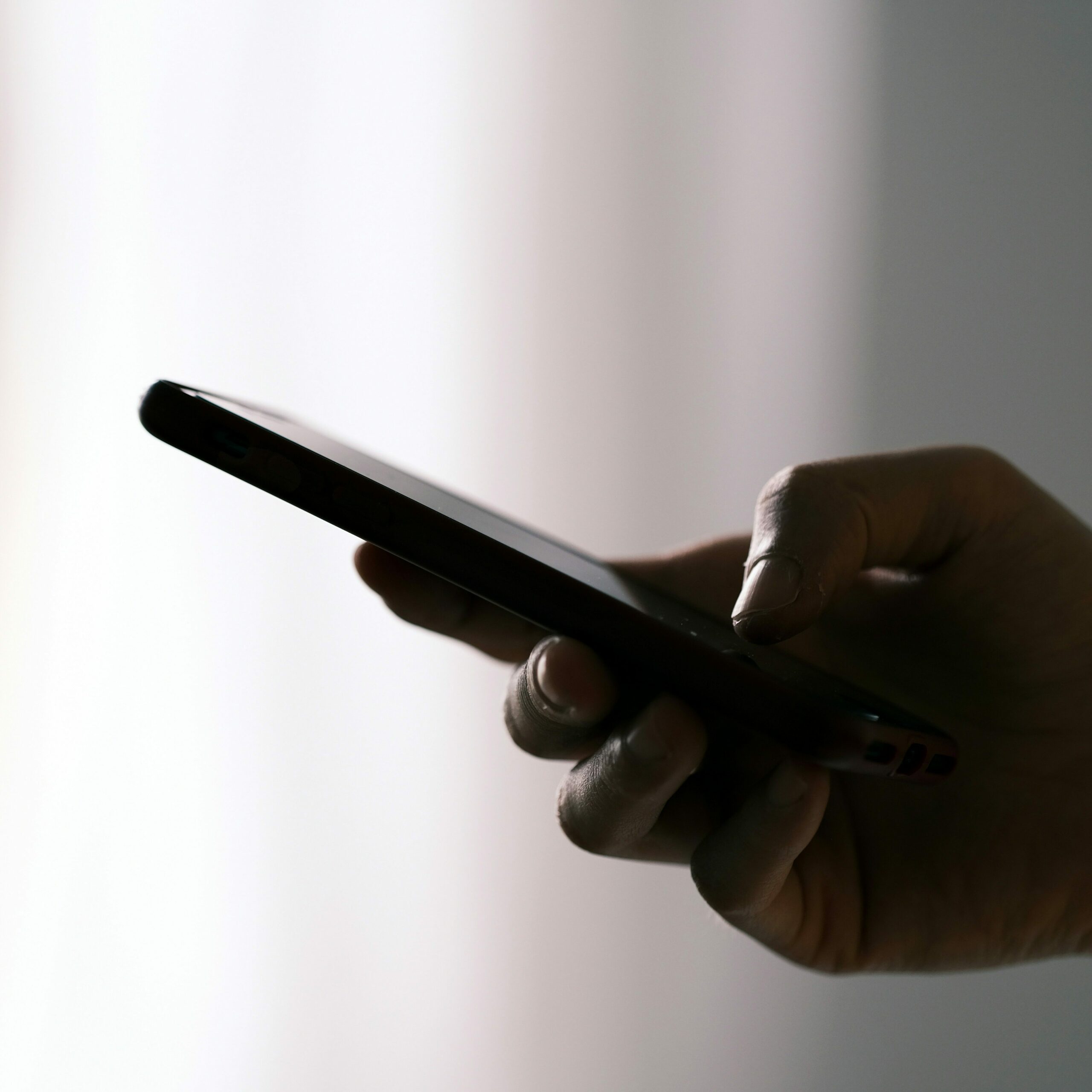 Echanger par téléphone Une main tient un téléphone. Cela vise à expliquer la première étape du déroulement de l'aventure biographique.