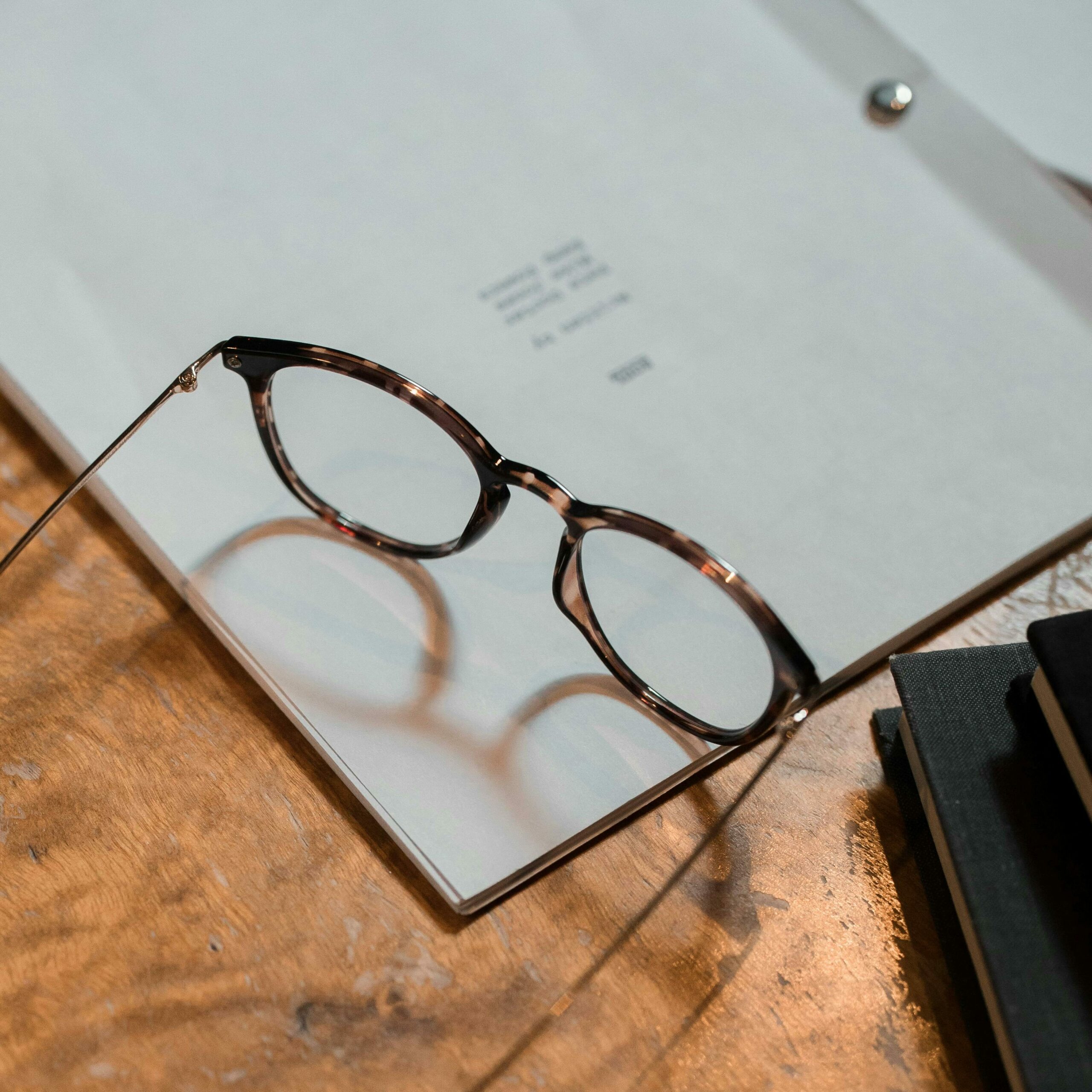 Correction d'un manuscrit Des lunettes de vue sont posées sur un manuscrit pour illustrer la phase de correction de l'ouvrage.