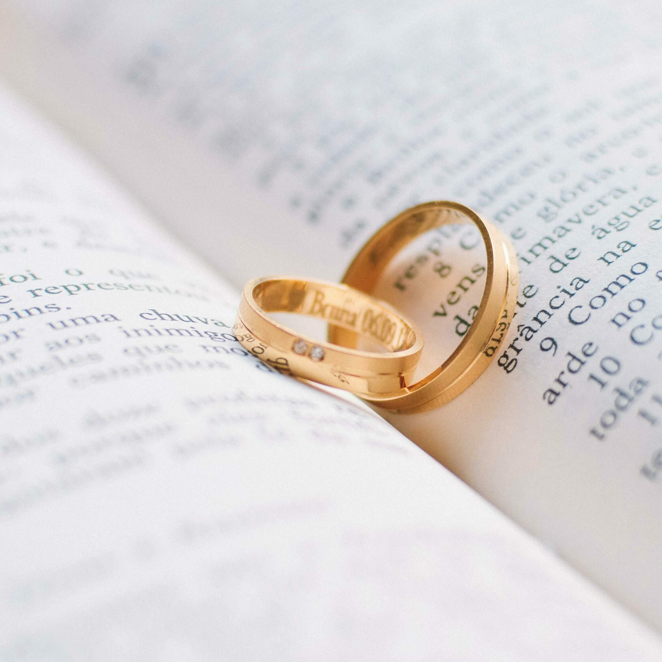alliances posées au centre d'un livre symbolisant une demande en mariage. Cela illustre le fait de pouvoir immortaliser cet instant de vie.